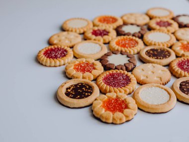 Farklı bisküviler, tatlılar ve kurabiye çerçevesi karışımı. Beyaz ahşap zemin üzerinde fotokopi alanı olan bir masa manzarası. Tatil pişirme konsepti. Kurabiyelerin arka planı çeşitlendirilmiş yakın plan