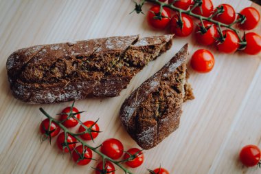 Fırında sarımsaklı ekmek, otlar ve domateslerle.