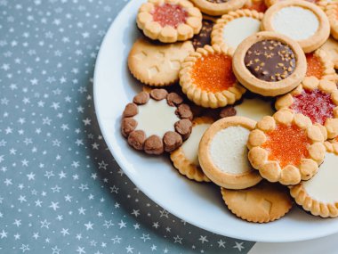 Farklı bisküviler, tatlılar ve kurabiye çerçevesi karışımı. Beyaz ahşap zemin üzerinde fotokopi alanı olan bir masa manzarası. Tatil pişirme konsepti. Kurabiyelerin arka planı çeşitlendirilmiş yakın plan