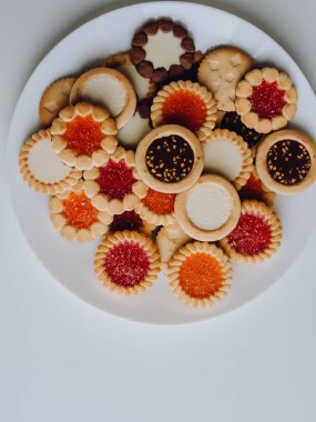 Farklı bisküviler, tatlılar ve kurabiye çerçevesi karışımı. Beyaz ahşap zemin üzerinde fotokopi alanı olan bir masa manzarası. Tatil pişirme konsepti. Kurabiyelerin arka planı çeşitlendirilmiş yakın plan