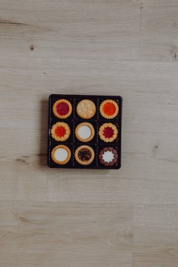 Farklı bisküviler, tatlılar ve kurabiye çerçevesi karışımı. Beyaz ahşap zemin üzerinde fotokopi alanı olan bir masa manzarası. Tatil pişirme konsepti. Kurabiyelerin arka planı çeşitlendirilmiş yakın plan