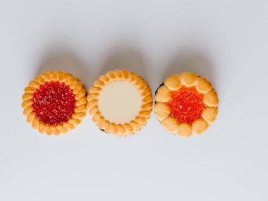 Farklı bisküviler, tatlılar ve kurabiye çerçevesi karışımı. Beyaz ahşap zemin üzerinde fotokopi alanı olan bir masa manzarası. Tatil pişirme konsepti. Kurabiyelerin arka planı çeşitlendirilmiş yakın plan