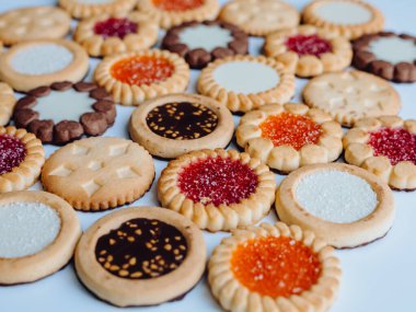 Farklı bisküviler, tatlılar ve kurabiye çerçevesi karışımı. Beyaz ahşap zemin üzerinde fotokopi alanı olan bir masa manzarası. Tatil pişirme konsepti. Kurabiyelerin arka planı çeşitlendirilmiş yakın plan