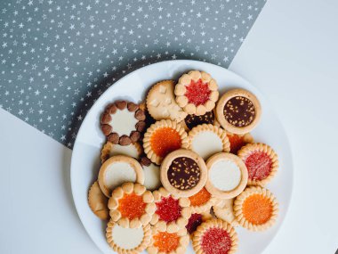 Farklı bisküviler, tatlılar ve kurabiye çerçevesi karışımı. Beyaz ahşap zemin üzerinde fotokopi alanı olan bir masa manzarası. Tatil pişirme konsepti. Kurabiyelerin arka planı çeşitlendirilmiş yakın plan