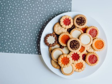 Farklı bisküviler, tatlılar ve kurabiye çerçevesi karışımı. Beyaz ahşap zemin üzerinde fotokopi alanı olan bir masa manzarası. Tatil pişirme konsepti. Kurabiyelerin arka planı çeşitlendirilmiş yakın plan