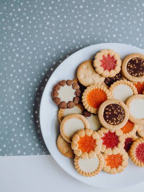 Farklı bisküviler, tatlılar ve kurabiye çerçevesi karışımı. Beyaz ahşap zemin üzerinde fotokopi alanı olan bir masa manzarası. Tatil pişirme konsepti. Kurabiyelerin arka planı çeşitlendirilmiş yakın plan