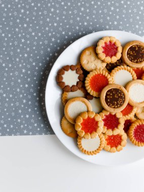 Farklı bisküviler, tatlılar ve kurabiye çerçevesi karışımı. Beyaz ahşap zemin üzerinde fotokopi alanı olan bir masa manzarası. Tatil pişirme konsepti. Kurabiyelerin arka planı çeşitlendirilmiş yakın plan
