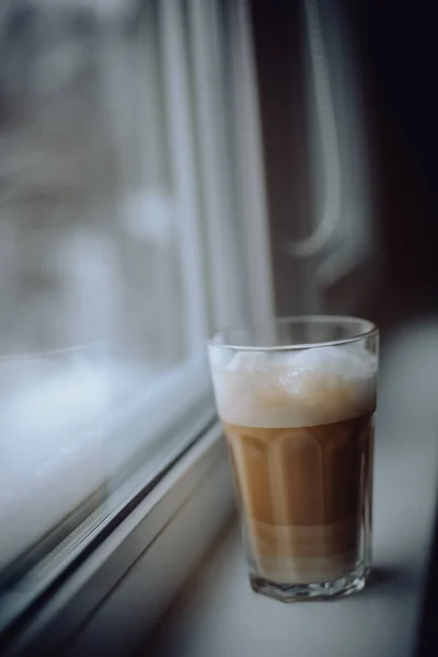 クリームを注いだ背の高いガラスの中のコーヒーラテ — ストック写真