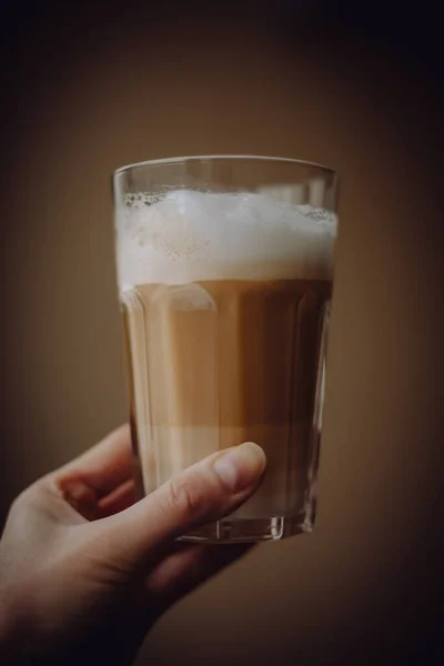 クリームを注いだ背の高いガラスの中のコーヒーラテ — ストック写真