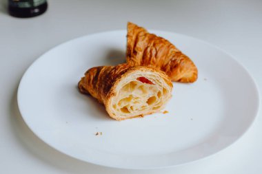 Akçaağaç şuruplu iki taze kruvasan beyaz arka planda izole edilmiş.