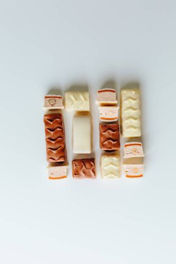 Çikolata piramidi. Beyaz ve koyu arkaplan üzerine izole edilmiş, fındıklı çikolataya (karamel kaplı, sütlü çikolatayla kaplı) yakın plan. Çikolata parçaları..