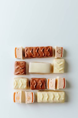 Çikolata piramidi. Beyaz ve koyu arkaplan üzerine izole edilmiş, fındıklı çikolataya (karamel kaplı, sütlü çikolatayla kaplı) yakın plan. Çikolata parçaları..