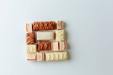 Çikolata piramidi. Beyaz ve koyu arkaplan üzerine izole edilmiş, fındıklı çikolataya (karamel kaplı, sütlü çikolatayla kaplı) yakın plan. Çikolata parçaları..