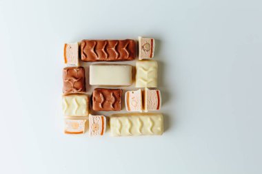 Çikolata piramidi. Beyaz ve koyu arkaplan üzerine izole edilmiş, fındıklı çikolataya (karamel kaplı, sütlü çikolatayla kaplı) yakın plan. Çikolata parçaları..