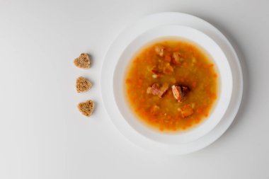 Baklagilleri ve sebzeleri bir kasede pişirdim. Ribollita geleneksel kuru bezelye çorbası, doğranmış yeşil bezelye, domuz eti, pastırma. Lezzetli, iştah açıcı, yağlı, bezelye çorbası, kızarmış ekmekle süslenmiş. Alman bezelye çorbası ve pastırma..