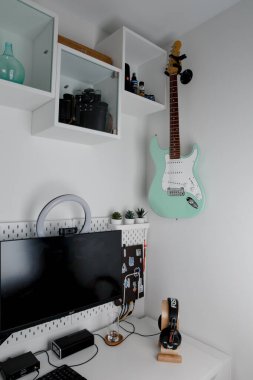 Beyaz bir duvarda yeşil elektro gitar sörfü.