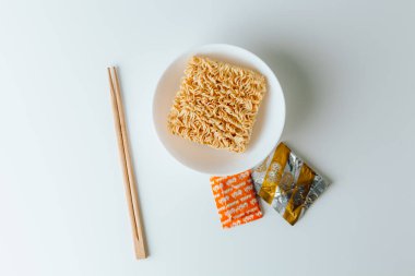 Beyaz arka planda çiğ Asya baharatlı erişte ve çubuklar..