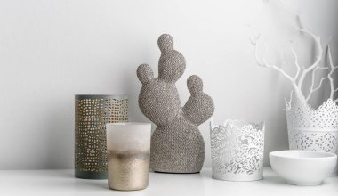 Dekoratif yapay seramik kaktüs, beyaz duvar zemininde sulu ve kaktüsler. Mumlar ve şamdanlar.