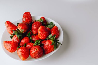 Beyaz arka planda duran büyük bir kırmızı sulu tatlı ve en güzel çilek grubu. Taze çilek duvar kağıdı. Taze organik böğürtlen makrosu. Meyve arkaplanı.