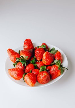 Beyaz arka planda duran büyük bir kırmızı sulu tatlı ve en güzel çilek grubu. Taze çilek duvar kağıdı. Taze organik böğürtlen makrosu. Meyve arkaplanı.