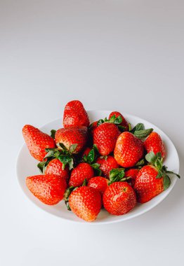 Beyaz arka planda duran büyük bir kırmızı sulu tatlı ve en güzel çilek grubu. Taze çilek duvar kağıdı. Taze organik böğürtlen makrosu. Meyve arkaplanı.