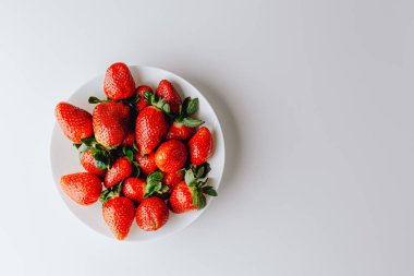 Beyaz arka planda duran büyük bir kırmızı sulu tatlı ve en güzel çilek grubu. Taze çilek duvar kağıdı. Taze organik böğürtlen makrosu. Meyve arkaplanı.