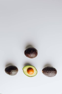 Yeşil ve beyaz arka planda taze organik avokadolar. Kırpma yolu ile. Taze, yarım ve dilimlenmiş avokado izole, üst görünüm..