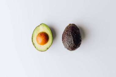 Yeşil ve beyaz arka planda taze organik avokadolar. Kırpma yolu ile. Taze, yarım ve dilimlenmiş avokado izole, üst görünüm..