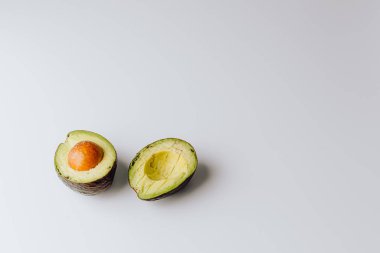 Yeşil ve beyaz arka planda taze organik avokadolar. Kırpma yolu ile. Taze, yarım ve dilimlenmiş avokado izole, üst görünüm..