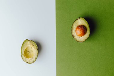 Yeşil ve beyaz arka planda taze organik avokadolar. Kırpma yolu ile. Taze, yarım ve dilimlenmiş avokado izole, üst görünüm..