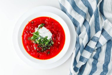 Pancar kırmızısı çorbası, pancar çorbası. Geleneksel Ukrayna ya da Rus çorbası, ekşi kremalı, taze maydanozlu ve dereotlu. Beyaz arkaplan. 