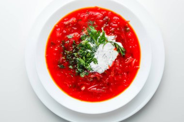 Pancar kırmızısı çorbası, pancar çorbası. Geleneksel Ukrayna ya da Rus çorbası, ekşi kremalı, taze maydanozlu ve dereotlu. Beyaz arkaplan. 