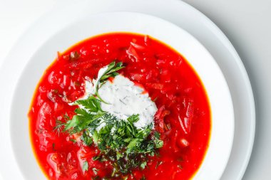 Pancar kırmızısı çorbası, pancar çorbası. Geleneksel Ukrayna ya da Rus çorbası, ekşi kremalı, taze maydanozlu ve dereotlu. Beyaz arkaplan. 