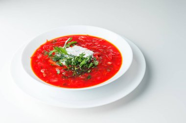 Pancar kırmızısı çorbası, pancar çorbası. Geleneksel Ukrayna ya da Rus çorbası, ekşi kremalı, taze maydanozlu ve dereotlu. Beyaz arkaplan. 