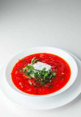 Pancar kırmızısı çorbası, pancar çorbası. Geleneksel Ukrayna ya da Rus çorbası, ekşi kremalı, taze maydanozlu ve dereotlu. Beyaz arkaplan. 
