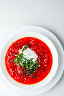 Pancar kırmızısı çorbası, pancar çorbası. Geleneksel Ukrayna ya da Rus çorbası, ekşi kremalı, taze maydanozlu ve dereotlu. Beyaz arkaplan. 