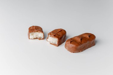 Fındıklı, lezzetli çikolatalar. Çikolatalı gofret Bounty. Beyaz arka planda izole edilmiş Snickers çubuğu. Çikolata parçaları.. 