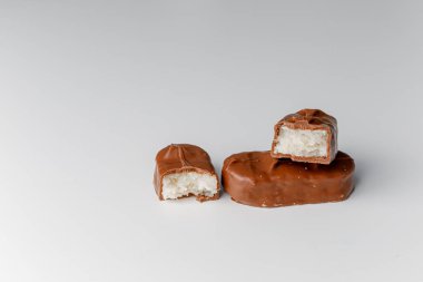 Fındıklı, lezzetli çikolatalar. Çikolatalı gofret Bounty. Beyaz arka planda izole edilmiş Snickers çubuğu. Çikolata parçaları.. 