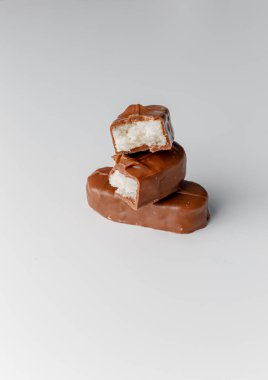 Fındıklı, lezzetli çikolatalar. Çikolatalı gofret Bounty. Beyaz arka planda izole edilmiş Snickers çubuğu. Çikolata parçaları.. 