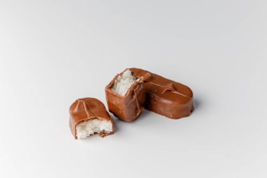 Fındıklı, lezzetli çikolatalar. Çikolatalı gofret Bounty. Beyaz arka planda izole edilmiş Snickers çubuğu. Çikolata parçaları.. 