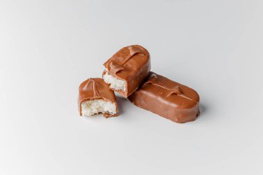 Fındıklı, lezzetli çikolatalar. Çikolatalı gofret Bounty. Beyaz arka planda izole edilmiş Snickers çubuğu. Çikolata parçaları.. 