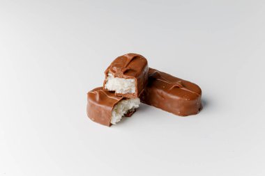 Fındıklı, lezzetli çikolatalar. Çikolatalı gofret Bounty. Beyaz arka planda izole edilmiş Snickers çubuğu. Çikolata parçaları.. 