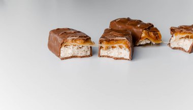 Fındıklı, lezzetli çikolatalar. Çikolatalı gofret Bounty. Beyaz arka planda izole edilmiş Snickers çubuğu. Çikolata parçaları.. 