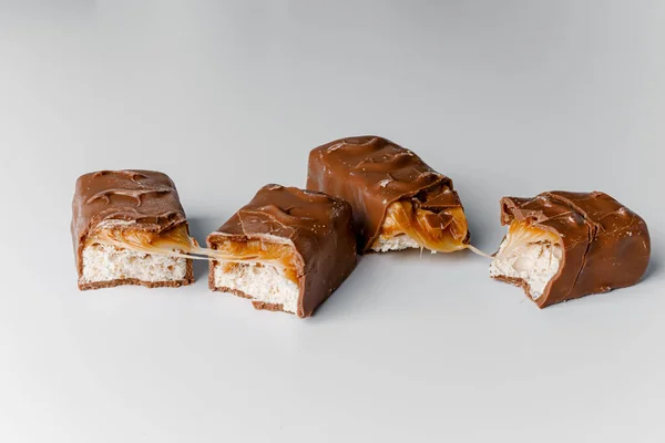 Delicious chocolate bars with nuts close up. Chocolate candy bar Bounty. Snickers bar isolated on white background. Pieces of chocolate bars.