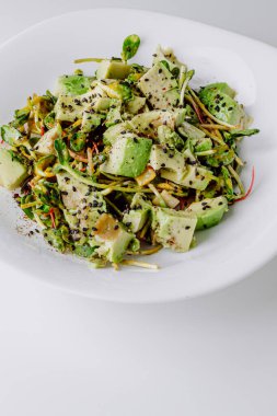 Beton arka planda avokado ve sos ile taze karışık salata. Buzdağından organik sağlıklı salata, avokado ve zeytinyağı ve susam tohumlu salatalık. Sağlıklı yeşil salata.. 