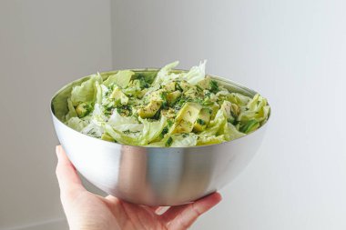 Avokado ve soslu taze karışık salata. Buzdağından organik sağlıklı salata, avokado ve zeytinyağı ve susam tohumlu salatalık. Sağlıklı yeşil salata.. 