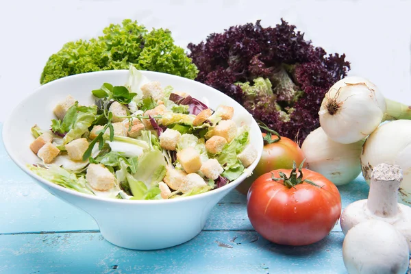 Grönsakssallad med tomater och sallad på vintage trä — Stockfoto