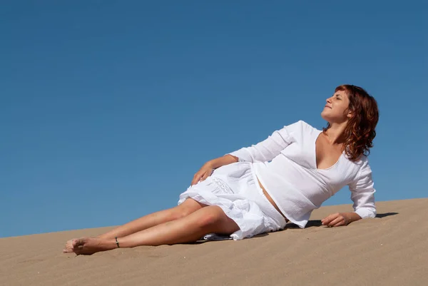 穿着白色衣服的女人在沙丘上悠闲自在 — 图库照片