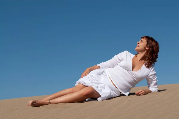 穿着白色衣服的女人在沙丘上悠闲自在 — 图库照片