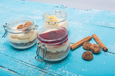 Meyve reçelli tatlı, cam kavanozlarda bisküvi ve içindekiler masada.